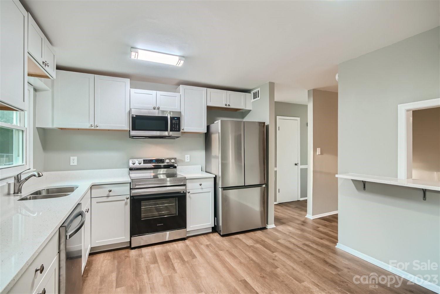 7438 Bramblewood Drive Charlotte, NC 28217 - Photo 8 of 27 a kitchen with a sink a stove and refrigerator