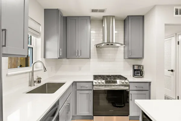 a kitchen with stainless steel appliances granite countertop a sink stove and cabinets