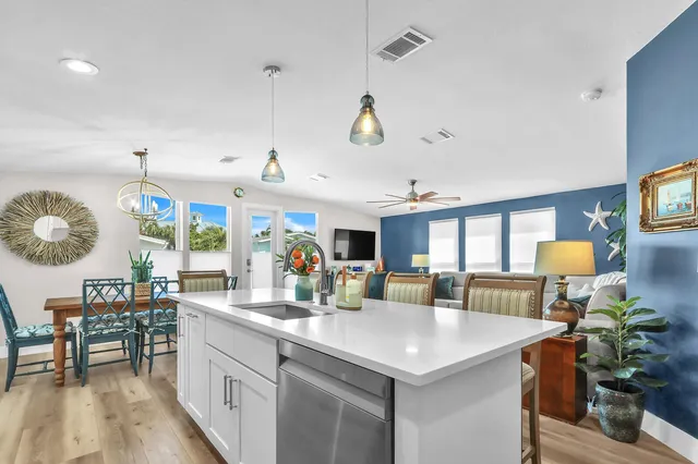 a kitchen with stainless steel appliances granite countertop a sink a stove and a wooden floors