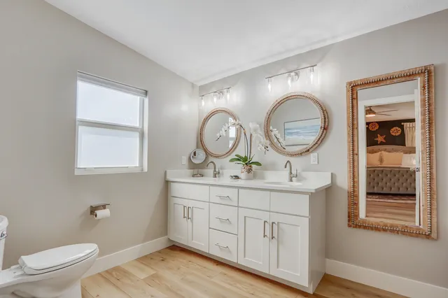 a bathroom with a toilet a sink and a mirror