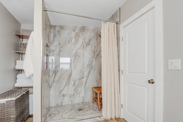 a bathroom with a shower and a glass door