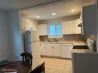 a kitchen with a refrigerator and a stove top oven