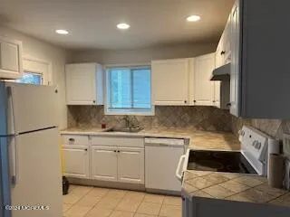 a kitchen with white cabinets and white appliances