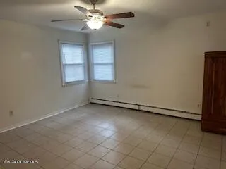 an empty room with windows and fan