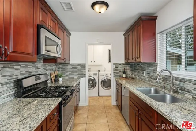 a kitchen with stainless steel appliances granite countertop a sink stove and cabinets
