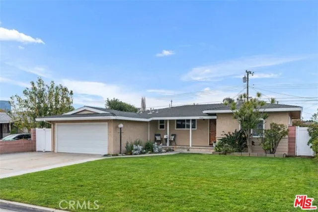 a front view of house with a garden
