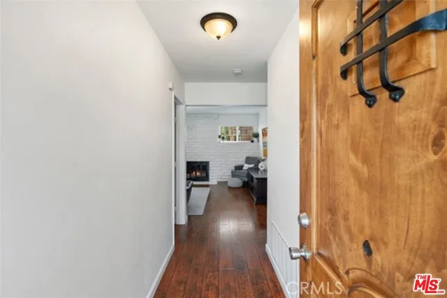a view of a hallway with wooden floor and a bathroom