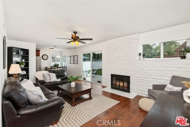 a living room with furniture fireplace and a large window