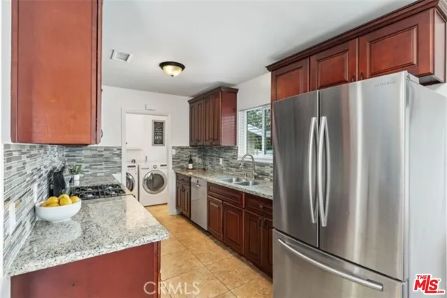 a kitchen with stainless steel appliances granite countertop a refrigerator stove and sink