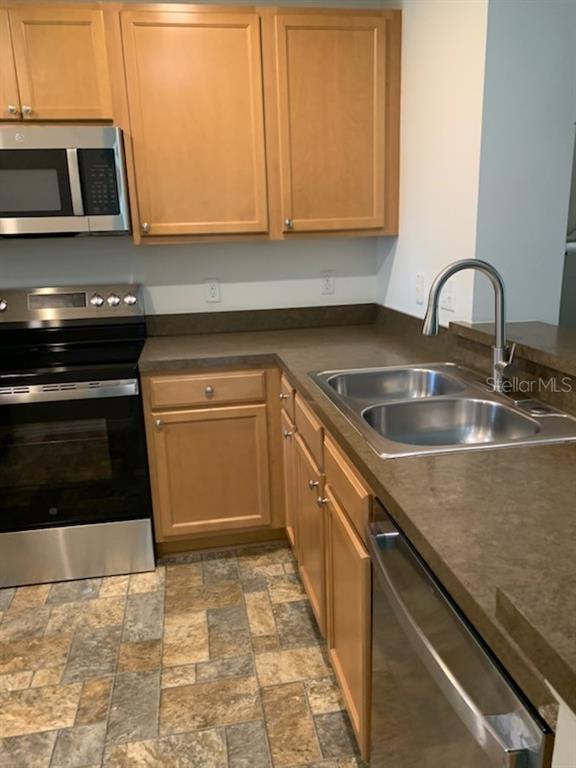 8893 White Sage Loop Lakewood Ranch, FL 34202 - Photo 2 of 14 a kitchen with granite countertop a stove a sink and a microwave