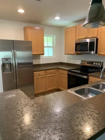 a kitchen with stainless steel appliances granite countertop a sink stove and refrigerator