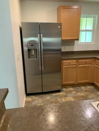 a kitchen with stainless steel appliances granite countertop a refrigerator a sink a stove and island