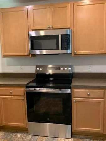 a kitchen with granite countertop a stove and a microwave