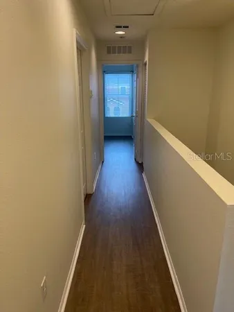 a view of an empty room and chandelier fan