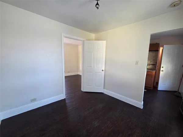 an empty room with wooden floor and closet