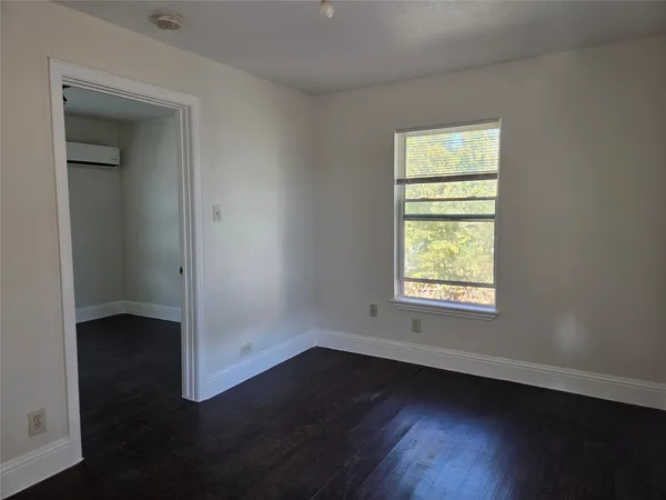 an empty room with wooden floor and a window