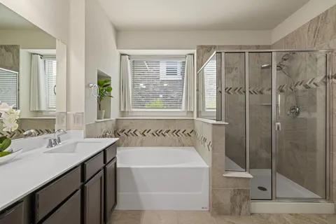 a bathroom with a tub sink and mirror