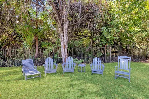 a view of park with bench and wooden fence