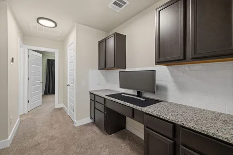 a view of kitchen with stainless steel appliances granite countertop cabinets and window