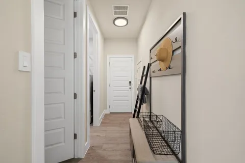 a view of a hallway with wooden floor and entryway