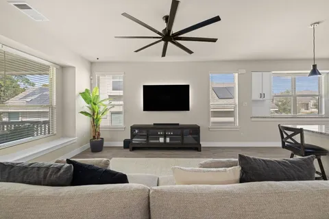 a living room with furniture a window and a flat screen tv
