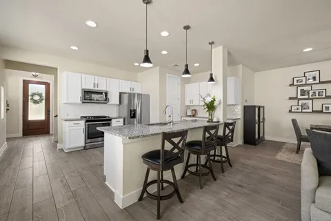 a large kitchen with a table and chairs