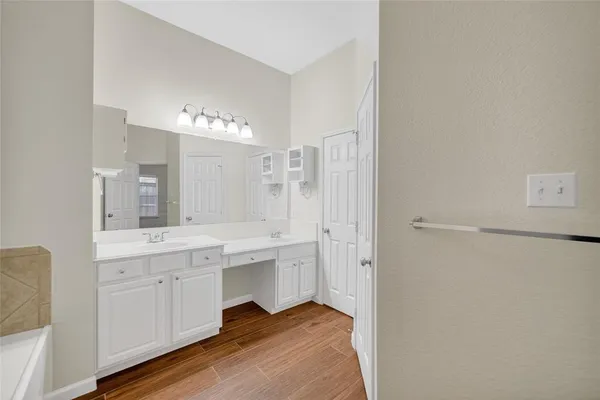a spacious bathroom with a double vanity sink a mirror and a bathtub