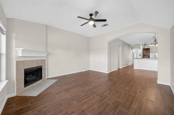 a view of empty room with wooden floor and fireplace