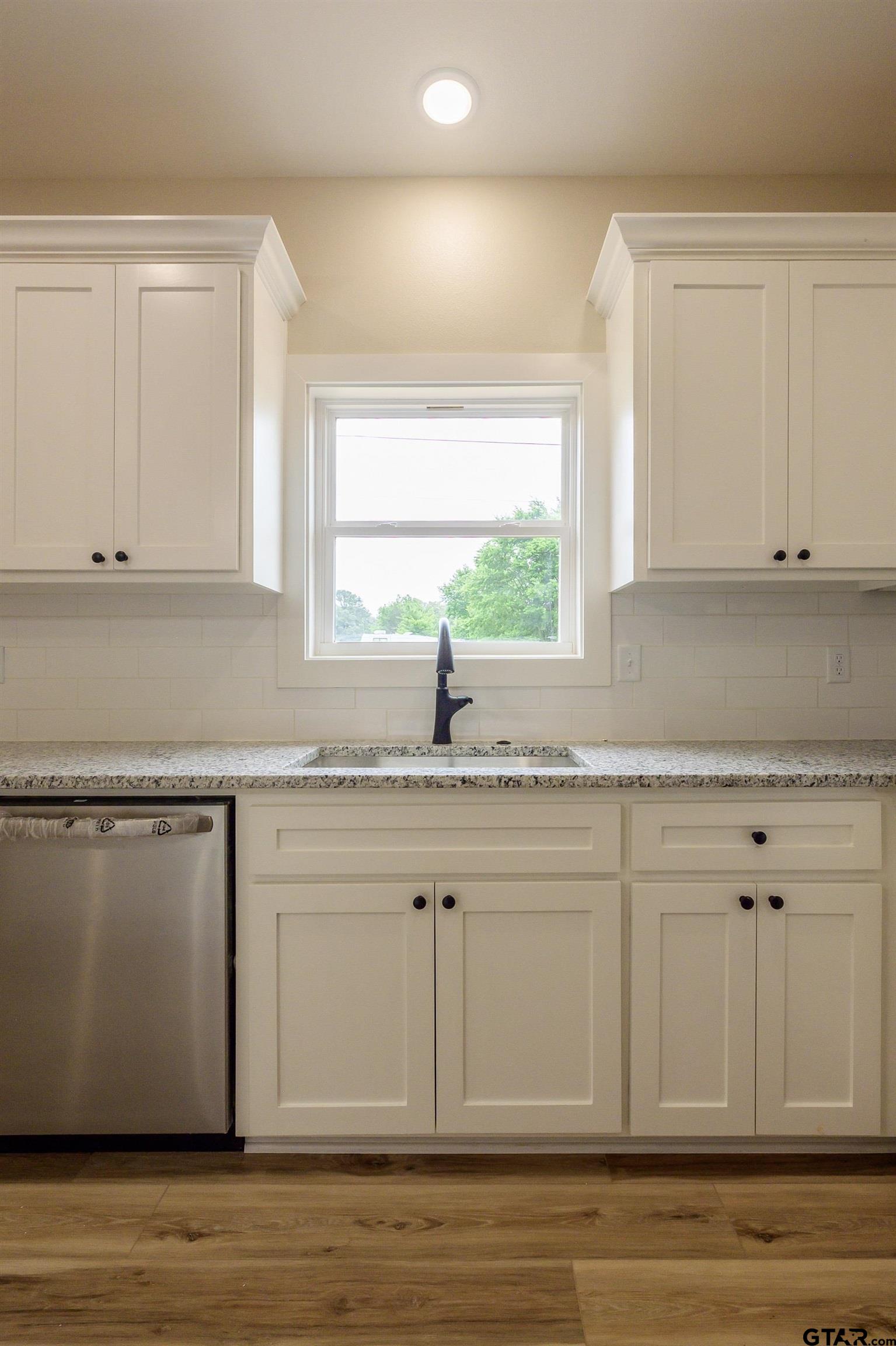 454 Crescent Bullard, TX 75757 - Photo 12 of 44 a kitchen with granite countertop white cabinets and a sink