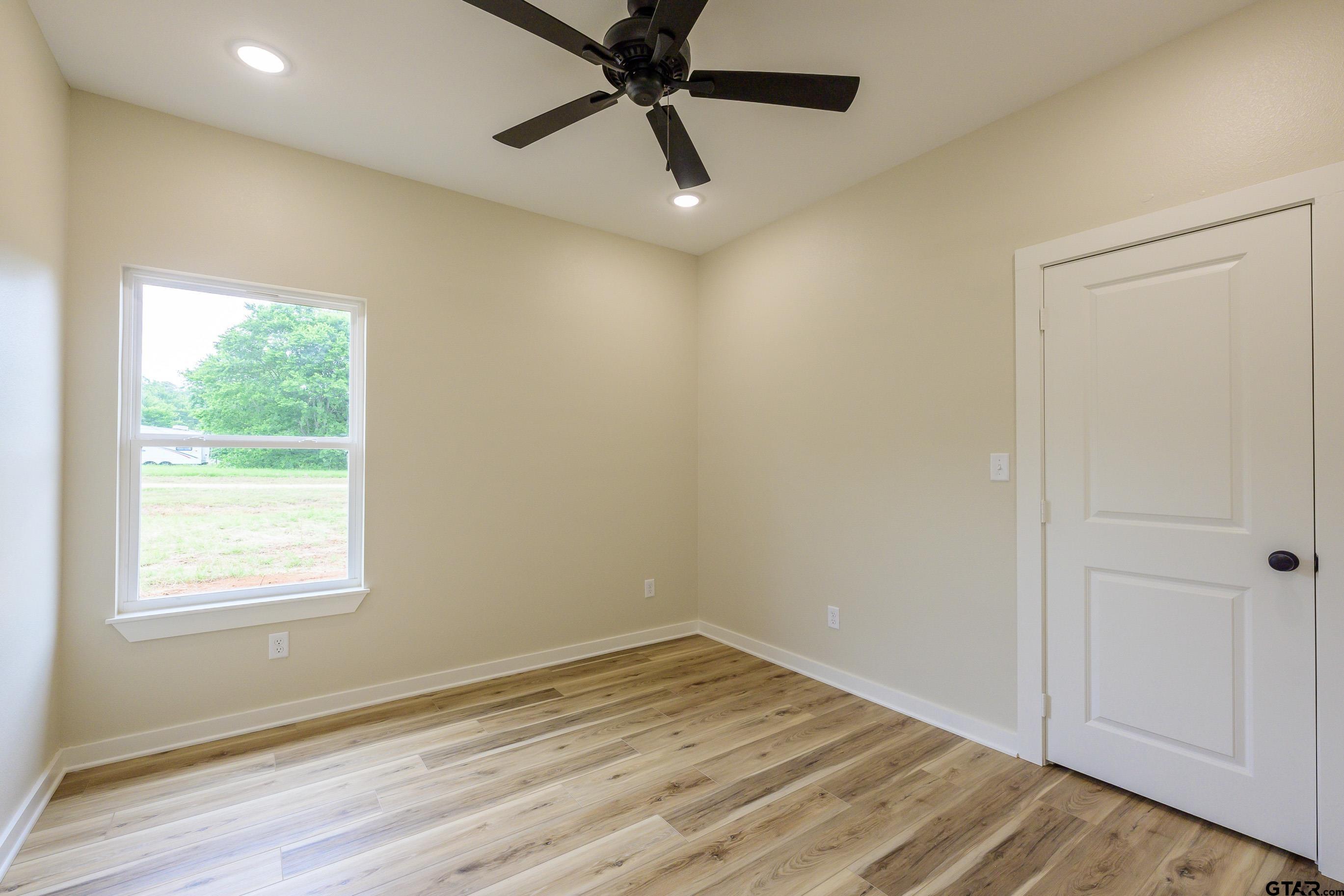 454 Crescent Bullard, TX 75757 - Photo 18 of 44 a view of empty room with wooden floor and fan