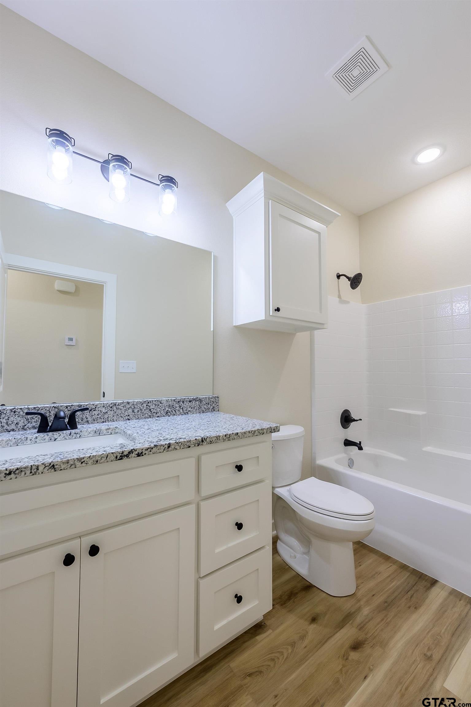 454 Crescent Bullard, TX 75757 - Photo 21 of 44 a bathroom with a granite countertop toilet a sink and a mirror
