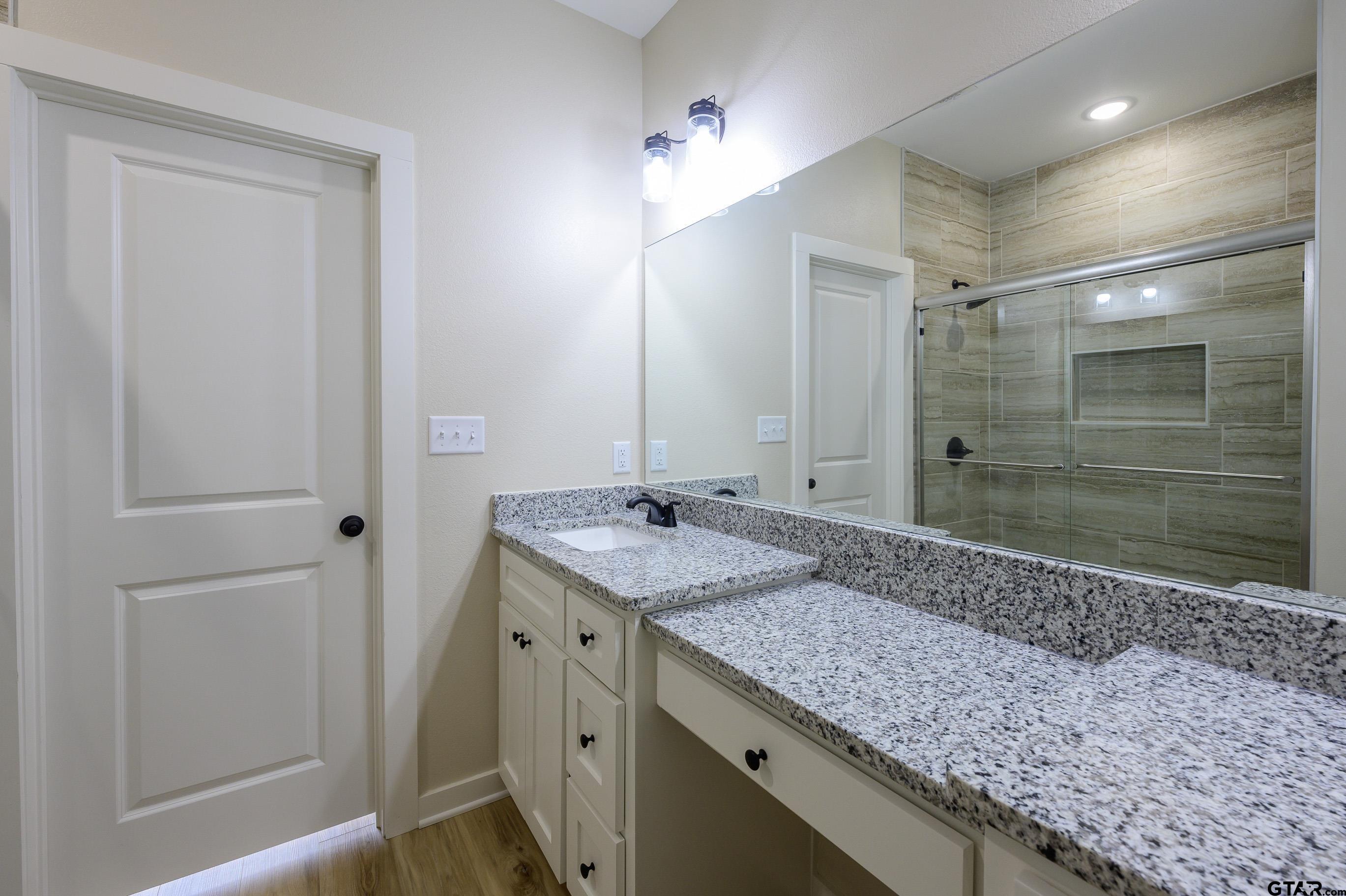 454 Crescent Bullard, TX 75757 - Photo 29 of 44 a bathroom with a granite countertop sink a mirror and shower