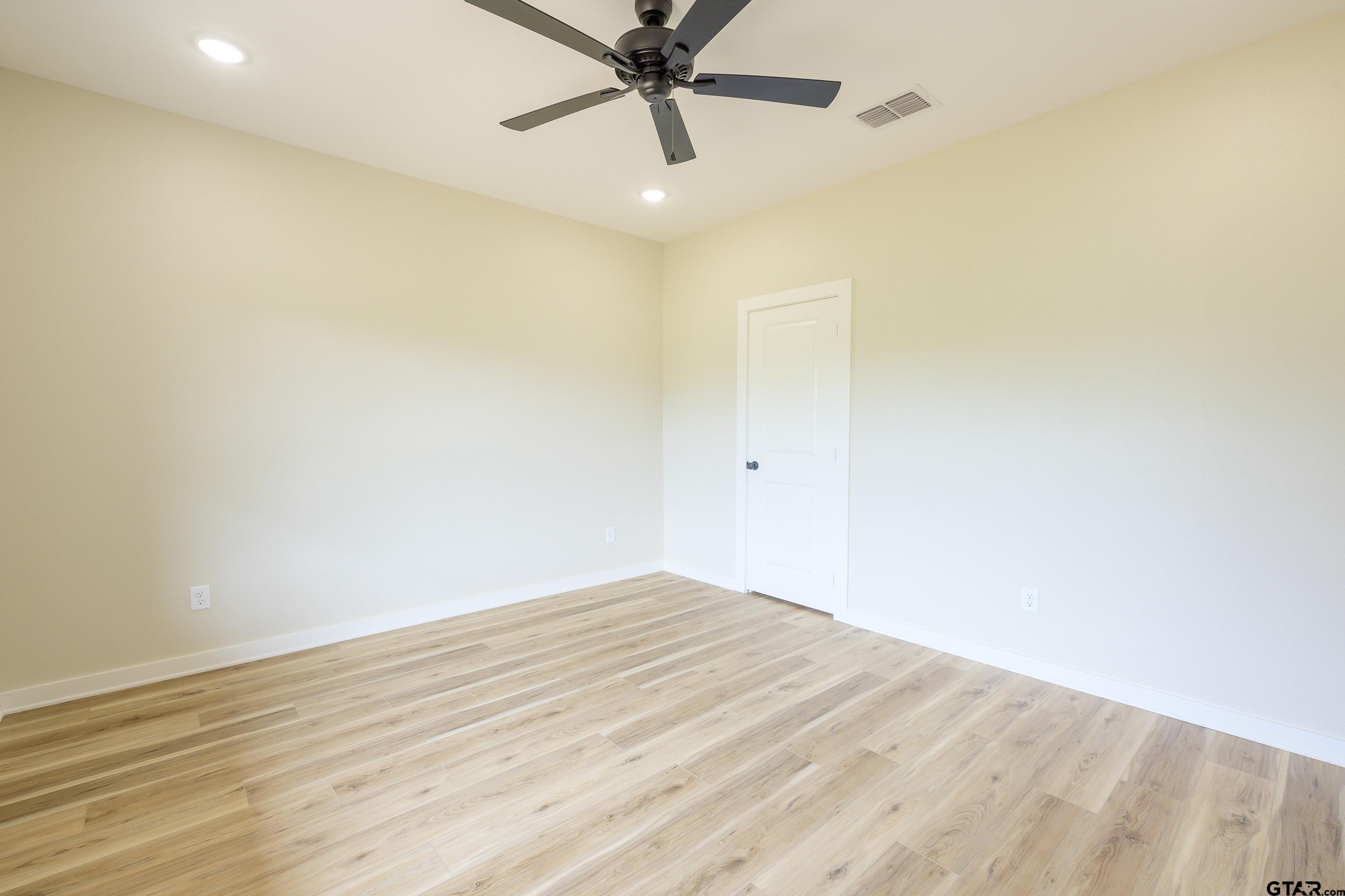 454 Crescent Bullard, TX 75757 - Photo 32 of 44 a view of a room with wooden floor and a ceiling fan