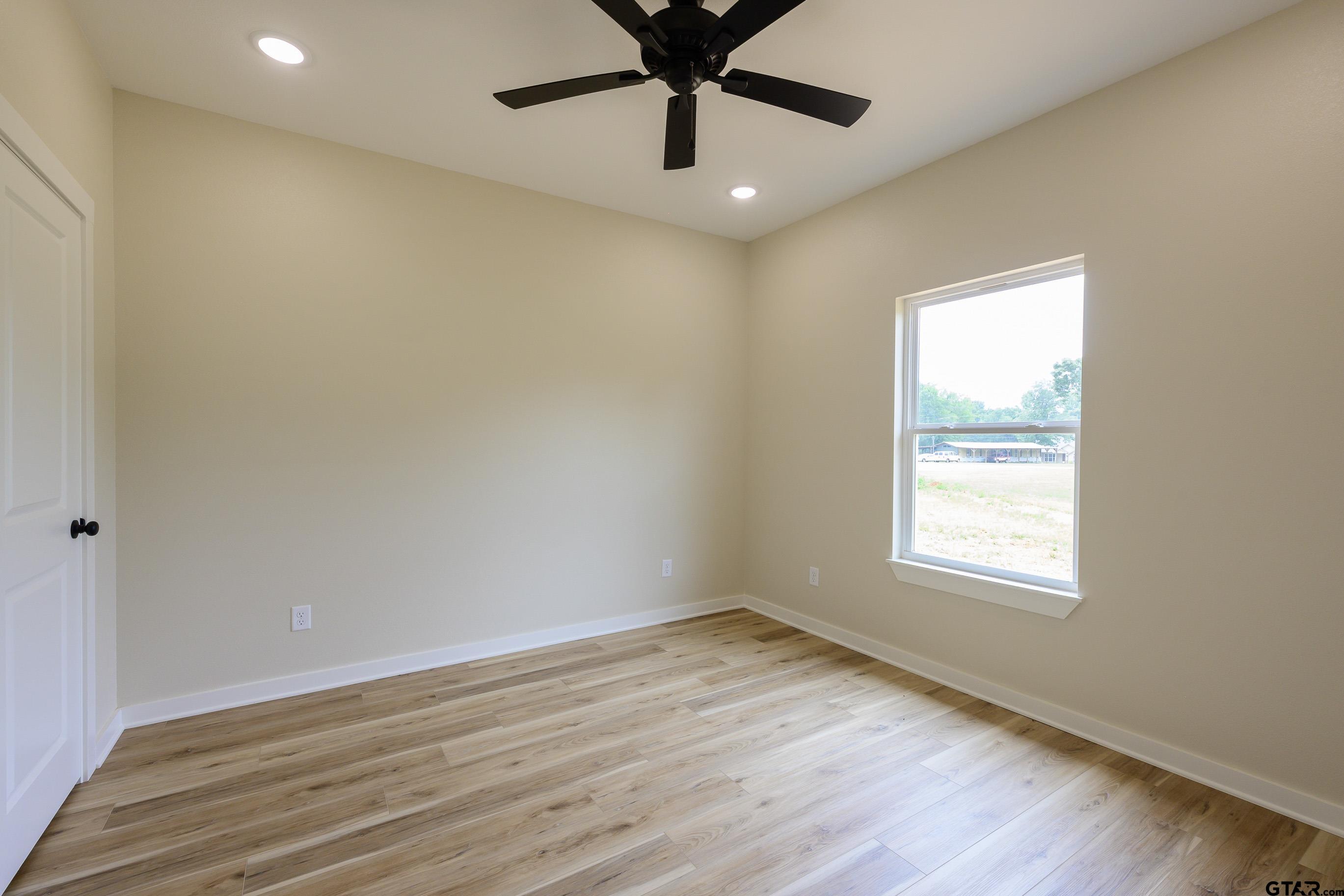 454 Crescent Bullard, TX 75757 - Photo 34 of 44 an empty room with wooden floor chandelier fan and windows