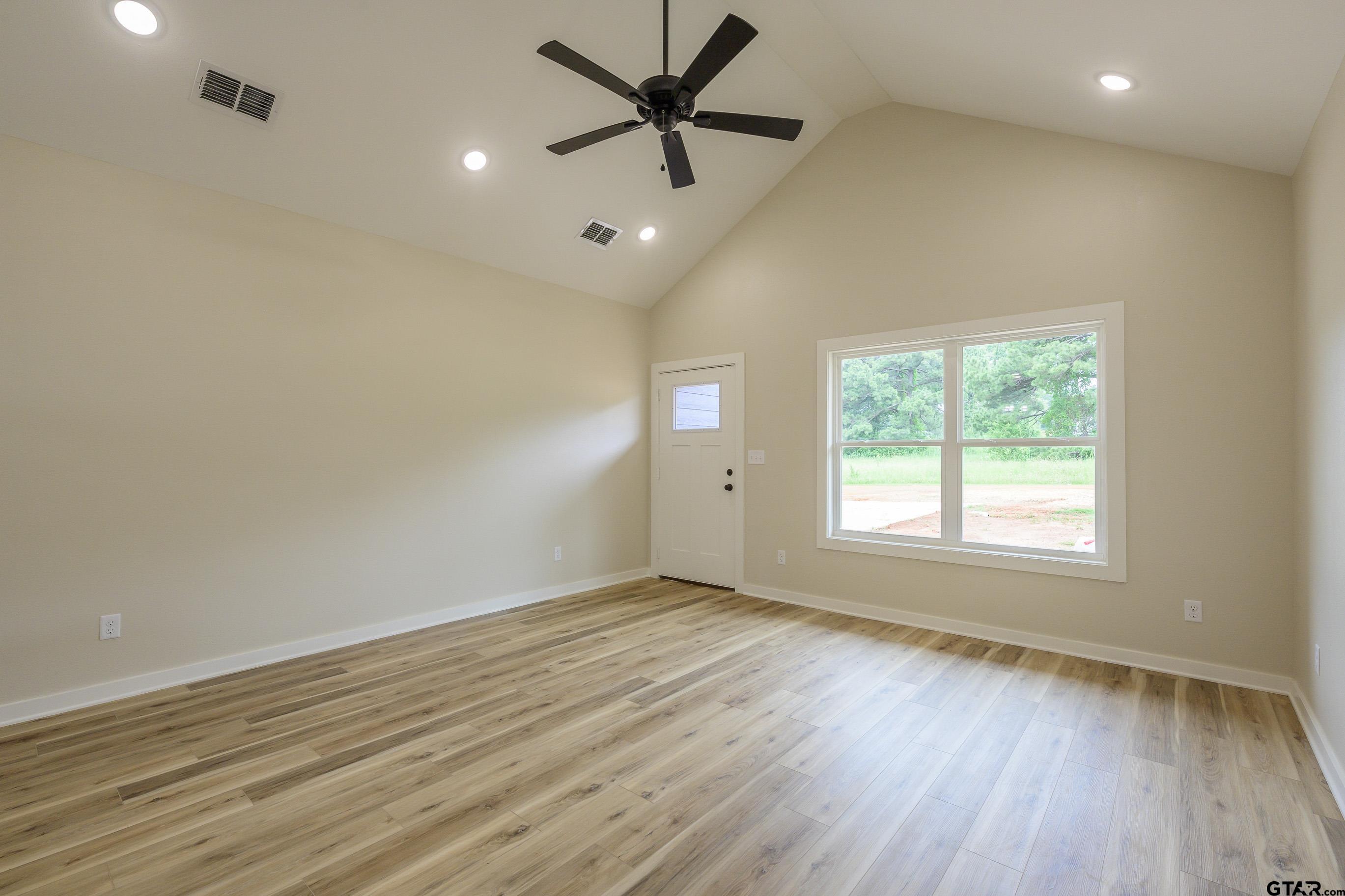 454 Crescent Bullard, TX 75757 - Photo 5 of 44 an empty room with wooden floor fan and windows