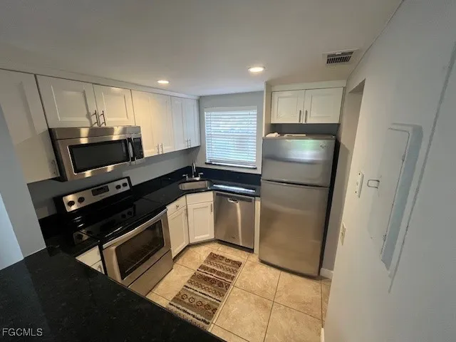 a kitchen with a refrigerator a stove and a sink