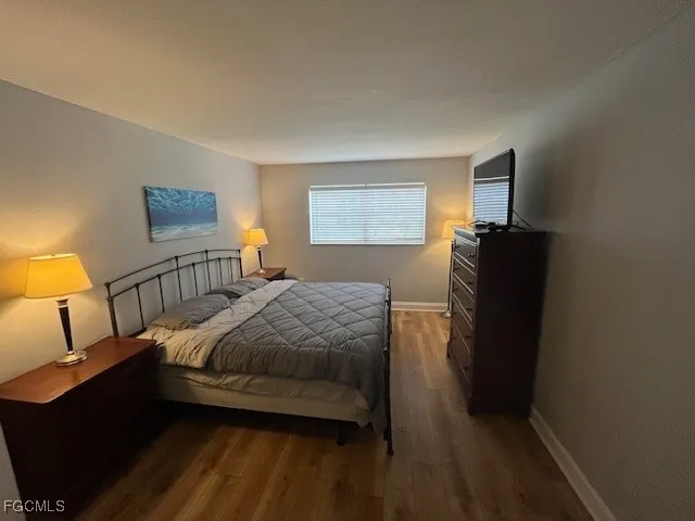 a bedroom with a bed and a large mirror on the dresser