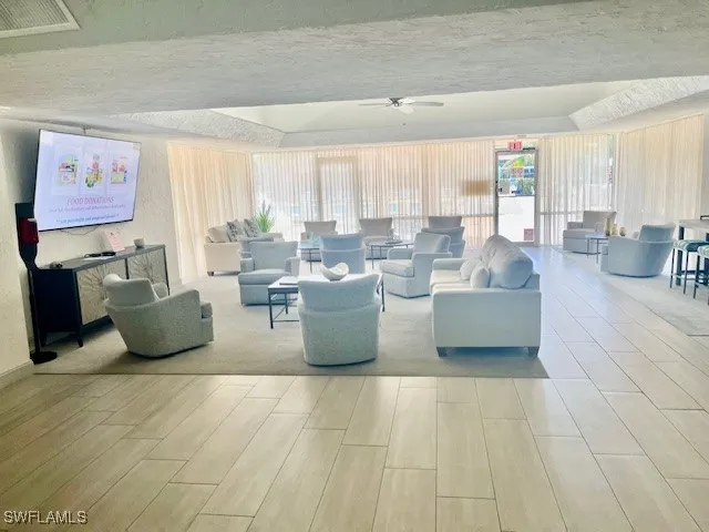 a view of a patio with couches table and chairs under an umbrella