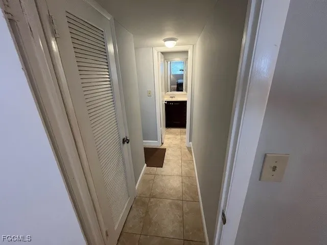 a bedroom with a bed and a lamp on dresser