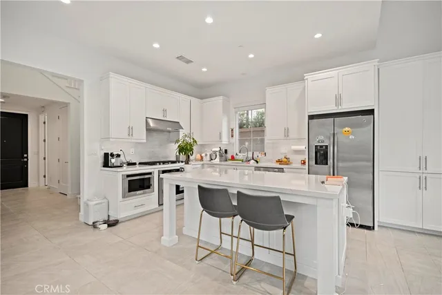 a large white kitchen with cabinets and stainless steel appliances