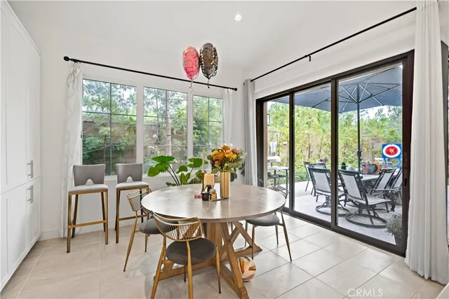 a very nice looking dining room with a large window and stainless steel appliances