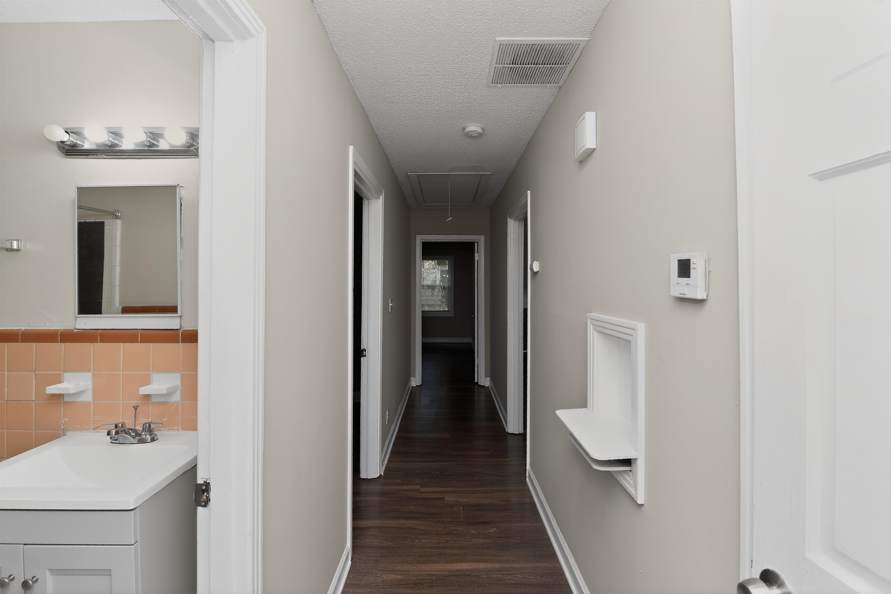 318 East Raines Road Memphis, TN 38109 - Photo 28 of 28 Hallway featuring wood-finish flooring, light grey wall paint, and white trim