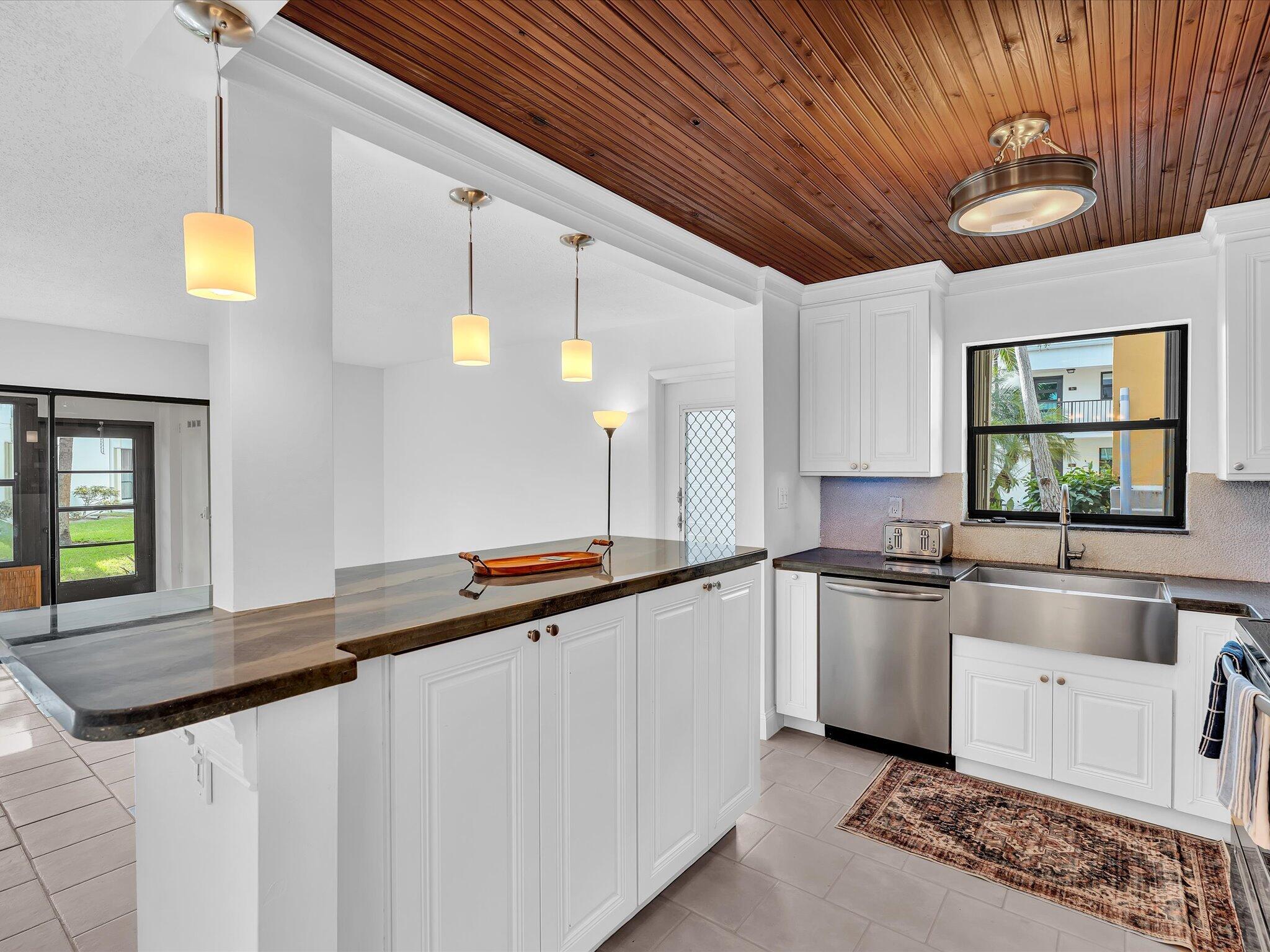 524 Osprey Drive, Unit 11B Delray Beach, FL 33444 - Photo 11 of 54 a large kitchen with granite countertop a sink and dishwasher a stove with wooden floor