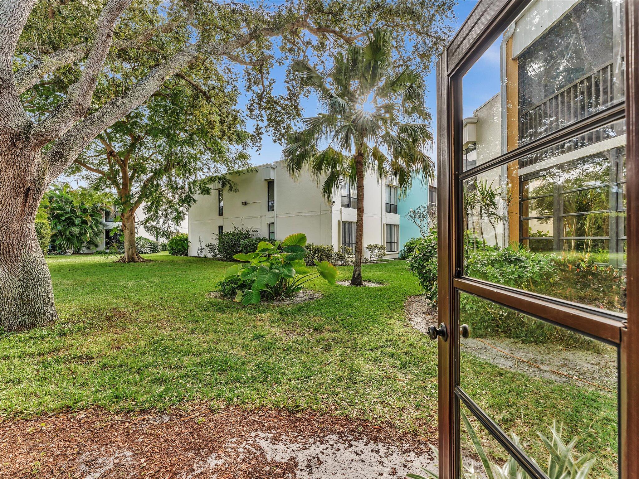 524 Osprey Drive, Unit 11B Delray Beach, FL 33444 - Photo 25 of 54 a view of a house with a yard and plants