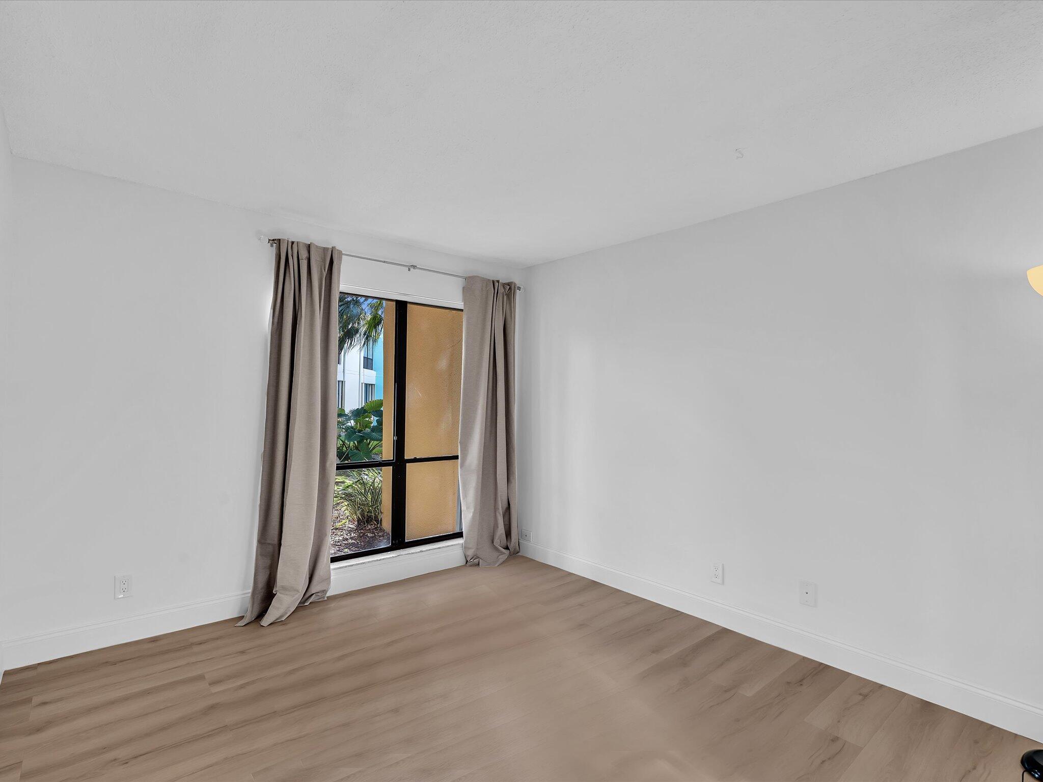 524 Osprey Drive, Unit 11B Delray Beach, FL 33444 - Photo 30 of 54 a view of an empty room with wooden floor and a window