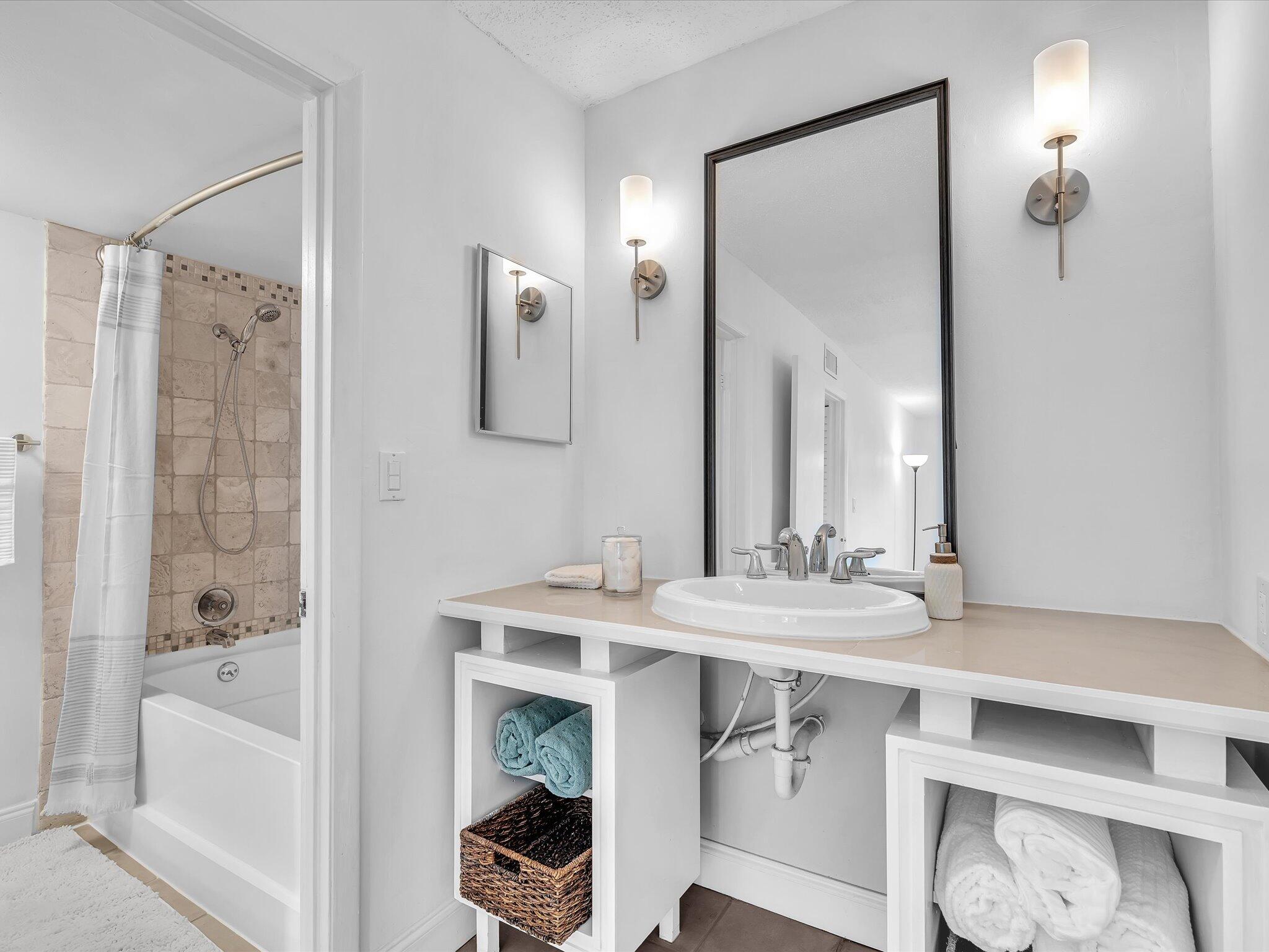 524 Osprey Drive, Unit 11B Delray Beach, FL 33444 - Photo 37 of 54 a bathroom with a tub sink and mirror