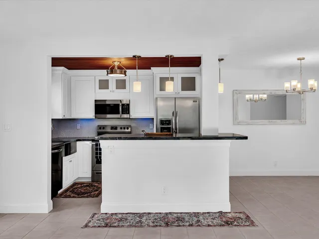 a kitchen with stainless steel appliances granite countertop a sink and a refrigerator