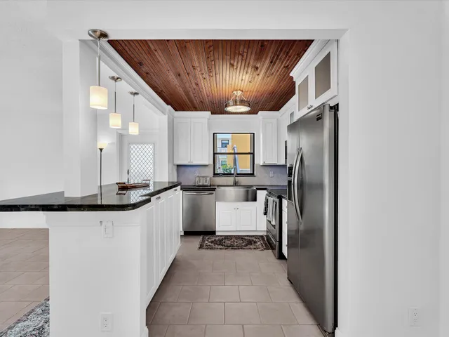 a kitchen with granite countertop a sink and refrigerator