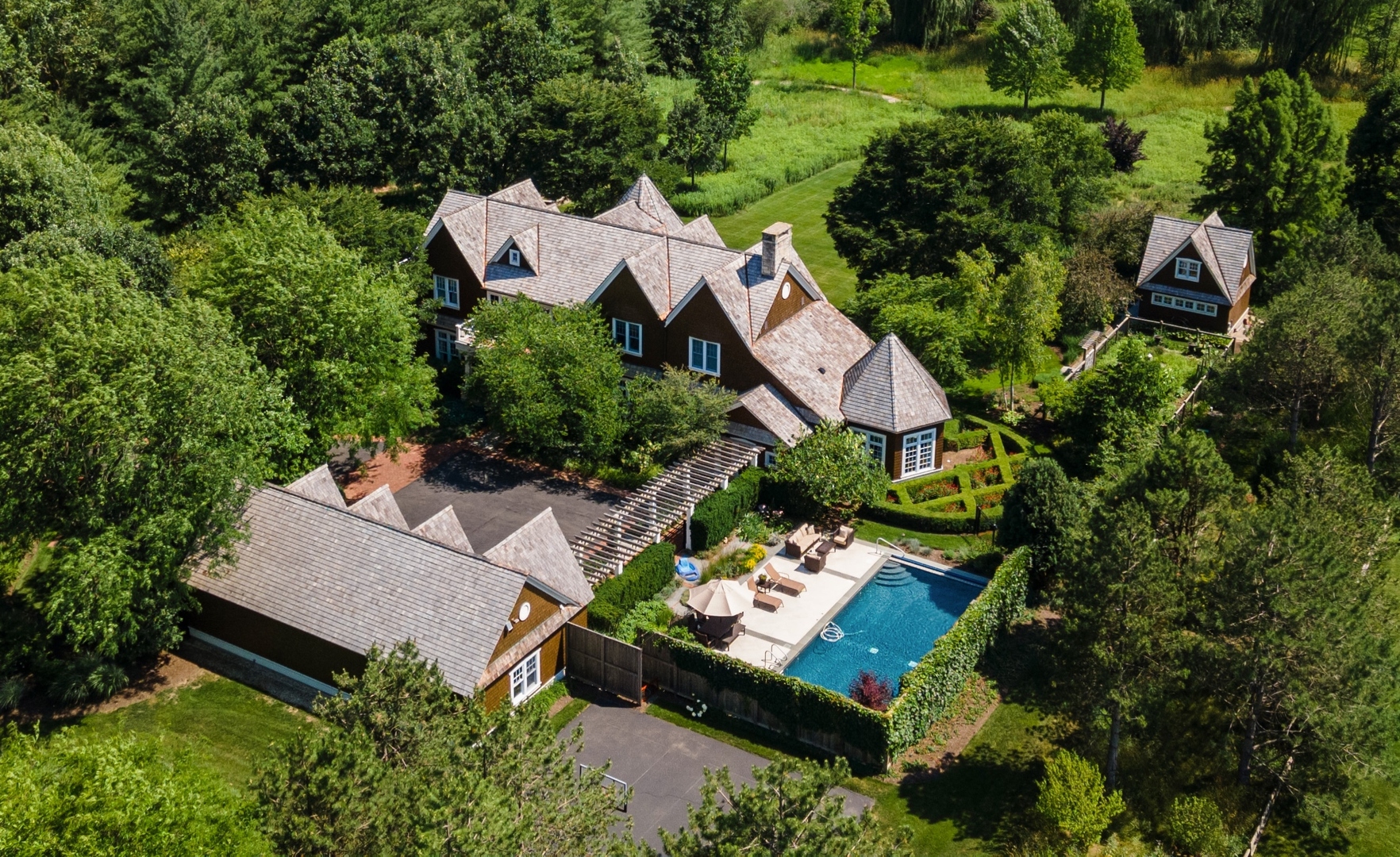an aerial view of a house with a yard lake and outdoor seating