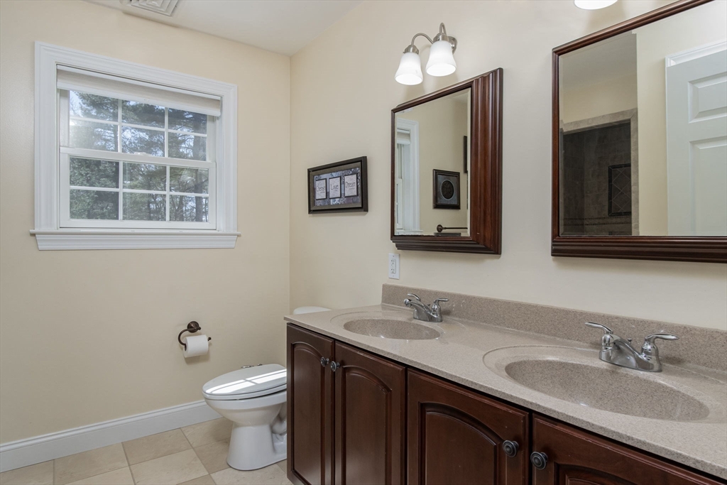 16 Mountain Laurel Road Ayer, MA 01432 - Photo 26 of 39 a bathroom with a toilet a sink a mirror and a window